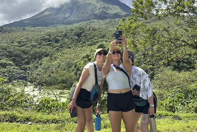 Friends in front of the Arenal Volcano and surrounding rainforest in La Fortuna, Costa Rica