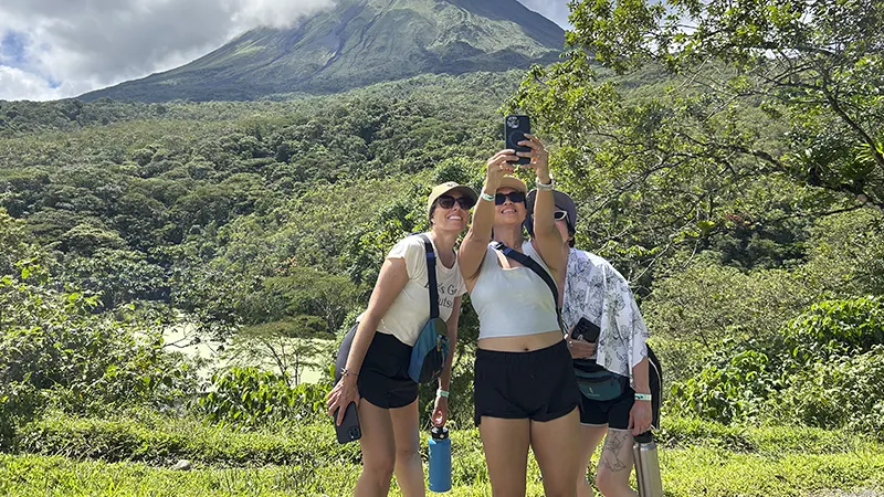 Friends in front of the Arenal Volcano and surrounding rainforest in La Fortuna, Costa Rica